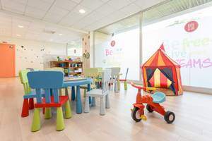 Kinderzimmer im Sarena de Muro Resort Mallorca mit bunten Stühlen und Tisch, Spielzeug und einem kleinen Zelt.