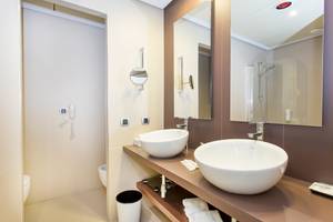 Badezimmer im Sarena de Muro Resort Mallorca mit zwei Waschbecken und Spiegeln.
