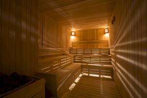 Innenansicht der Sauna im Voyage Sorgun Hotel mit Holzbänken und Beleuchtung.