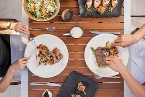 Personen essen an einem Tisch mit verschiedenen Gerichten im Voyage Sorgun.