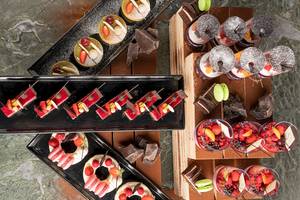 Vielfältige Desserts im Voyage Sorgun Hotel, darunter Früchte, Schokolade und Macarons.