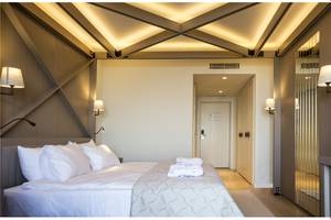 Ein modernes Schlafzimmer im Voyage Sorgun Hotel mit einem großen Bett und weißen Bettwäsche.