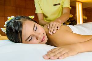Eine Frau genießt eine Massage im Spa des Seaview Patong Hotels, während eine Therapeutin ihr hilft.