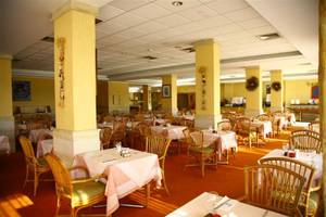 Innenansicht des Restaurants im Bella Napa Bay Hotel mit vielen gedeckten Tischen und Stühlen.