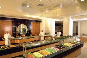 Buffettisch im Hotel Calypso Beach mit verschiedenen Gerichten und Köchen im Hintergrund.