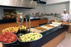 Ein Buffettisch im Calypso Beach Hotel mit verschiedenen Früchten und Desserts.