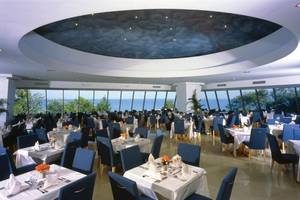 Innenansicht des Restaurants im Calypso Beach Hotel mit Blick auf das Meer.