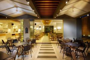 Innenansicht des Restaurants Anna's House mit runden Tischen und Stühlen, gefliestem Boden und Deckenbeleuchtung.