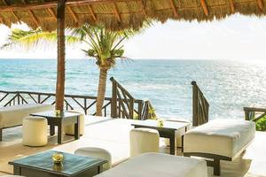 Außenbar des El Dorado Royale a Spa Resort mit Blick auf das Meer und tropischer Dekoration.