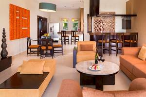 Innenbereich des El Dorado Royale Spa Resorts mit Wohnzimmer, Essbereich und Bar.
