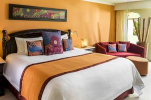 Hotelzimmer mit Bett und Sofa im El Dorado Royale a Spa Resort by Karisma