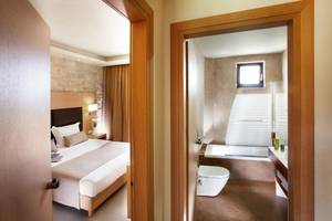 Innenansicht eines Hotelzimmers von Anna's House mit Bett, Badezimmer und Badewanne.