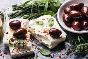 Alexander House Essen auf einem Tisch mit Feta, Oliven, Kräutern und Gewürzen.