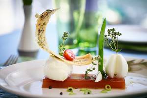 Gedeckter Tisch im Serita Beach Hotel mit einem Gericht aus Mozzarella, Tomaten und Gemüse.