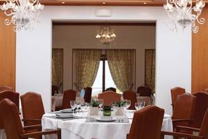 Innenansicht des Restaurants im Serita Beach Hotel mit gedecktem Tisch und eleganten Leuchten