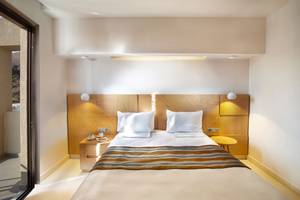 Ein modernes Zimmer von Anna's House mit einem Bett, Bettzeug und Nachttischen.