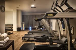 Fitnessraum im Grand Hotel Resort Ma&Ma mit drei Laufbändern und anderen Trainingsgeräten.