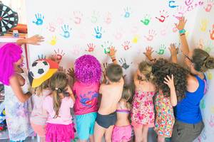 Kinder mit bunten Handabdrücken an einer Wand im Stella Village Hotel & Bungalows.