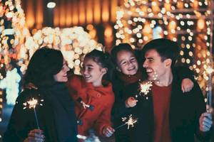 Eine Familie feiert das Fest der Lichter mit Feuerwerk und Lächeln.