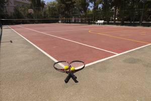 Tennisplatz im Seher Resort & Spa mit zwei Tennisschlägern und Bällen