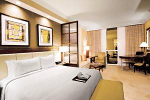 Hotelzimmer im The Signature at MGM Grand mit Bett, Schreibtisch und Fenstern.
