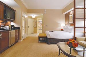 Hotelzimmer im The Signature at MGM Grand mit Bett, Küche und Wohnzimmer.
