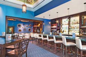 Innenbereich des Signature at MGM Grand Hotel mit Bar, Stühlen und Tischen, blaue Wände und Holzboden.
