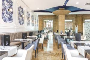 Innenansicht des Restaurants im Be Live Experience La Nina Hotel mit blauen Wandverkleidungen und runden Deckenleuchten.