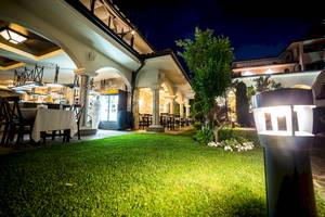 Außenbereich des Helena Sands Hotels bei Nacht mit beleuchteter Terrasse und Grünfläche.