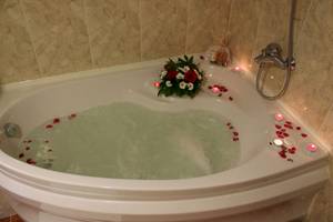 Whirlpool-Badewanne im Helena Sands Hotel mit Blumen und Kerzen.