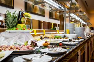 Buffet-Tisch im Helena Sands Hotel mit verschiedenen Gerichten und Salaten.