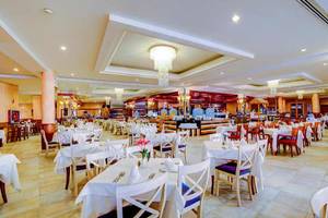 Innenansicht des Restaurants im SBH Costa Calma Beach Resort mit gedeckten Tischen und Stühlen.