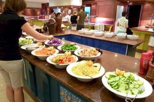 Frau bedient sich an einem Buffet im SBH Hotel Costa Calma Palace.
