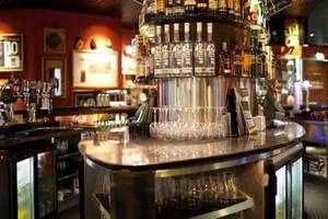 Die Bar im Manzil Downtown by Vida Hotel in Dubai mit verschiedenen Flaschen und Gläsern.