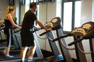 Fitnesscenter im Manzil Downtown Hotel in Dubai mit mehreren Personen auf Laufbändern.