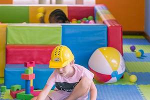 Kinder im Meeru Island Resort spielen in einem bunten Spielbereich mit Bällebad und Spielzeug.