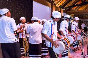 Gruppe von Musikern, die Trommeln spielen, vor einem Publikum im Meeru Island Resort & Spa.