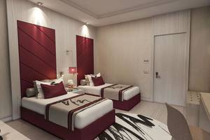 Zwei elegante Einzelbetten in einem modernen Zimmer des Delphin BE Grand Resort, mit stilvollem Dekor und Kontrasten.