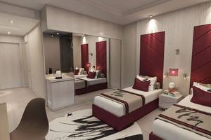 Moderne Hotelzimmer im Delphin BE Grand Resort mit zwei Einzelbetten und eleganter Einrichtung in neutralen Farben.