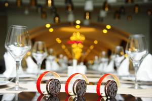 Elegant gedeckter Tisch im Delphin BE Grand Resort mit Gläsern und dekorativen Keks-Kreationen im Vordergrund.