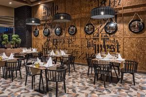 Ein elegantes Restaurant im Delphin BE Grand Resort mit stilvollen Tischen und modernen Lampen.
