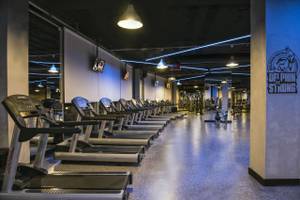 Fitnessraum im Delphin BE Grand Resort mit Laufbändern und moderner Ausstattung in gedämpftem Licht.
