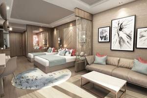 Modernes Zimmer im Delphin BE Grand Resort mit zwei Betten, Sofa und stilvollen Dekorationen.