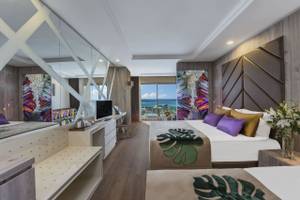 Elegantes Zimmer im Delphin BE Grand Resort mit Meerblick und modernem Dekor in warmen Farben.