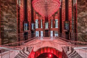 Elegante Hotellobby des Delphin BE Grand Resort mit rotem Kronleuchter und modernem Design.