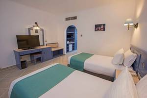 Zwei Betten in einem Hotelzimmer mit Fernseher und Schreibtisch.