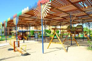 Kinderspielplatz im Sunrise Royal Makadi Resort mit bunten Holzspielgeräten und einem schattigen Pavillon.