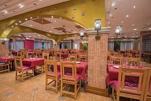 Innenansicht des Restaurants im Sunrise Royal Makadi Resort, mit gedeckten Tischen und Stühlen.