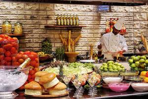 Buffet-Tisch im Diani Reef Beach Resort & Spa mit Salat, Obst und verschiedenen Gerichten.