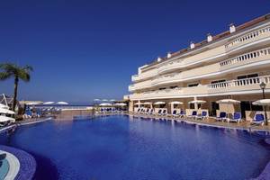 Außenbereich des Bahia Flamingo Hotels mit Swimmingpool, Sonnenliegen und Palme